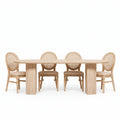 Dining room with a wooden table and chairs against a white paneled wall.