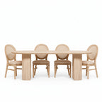 Dining room with a wooden table and chairs against a white paneled wall.