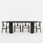 Dining room with a black oval table and chairs, featuring decorative items and a wall art piece.