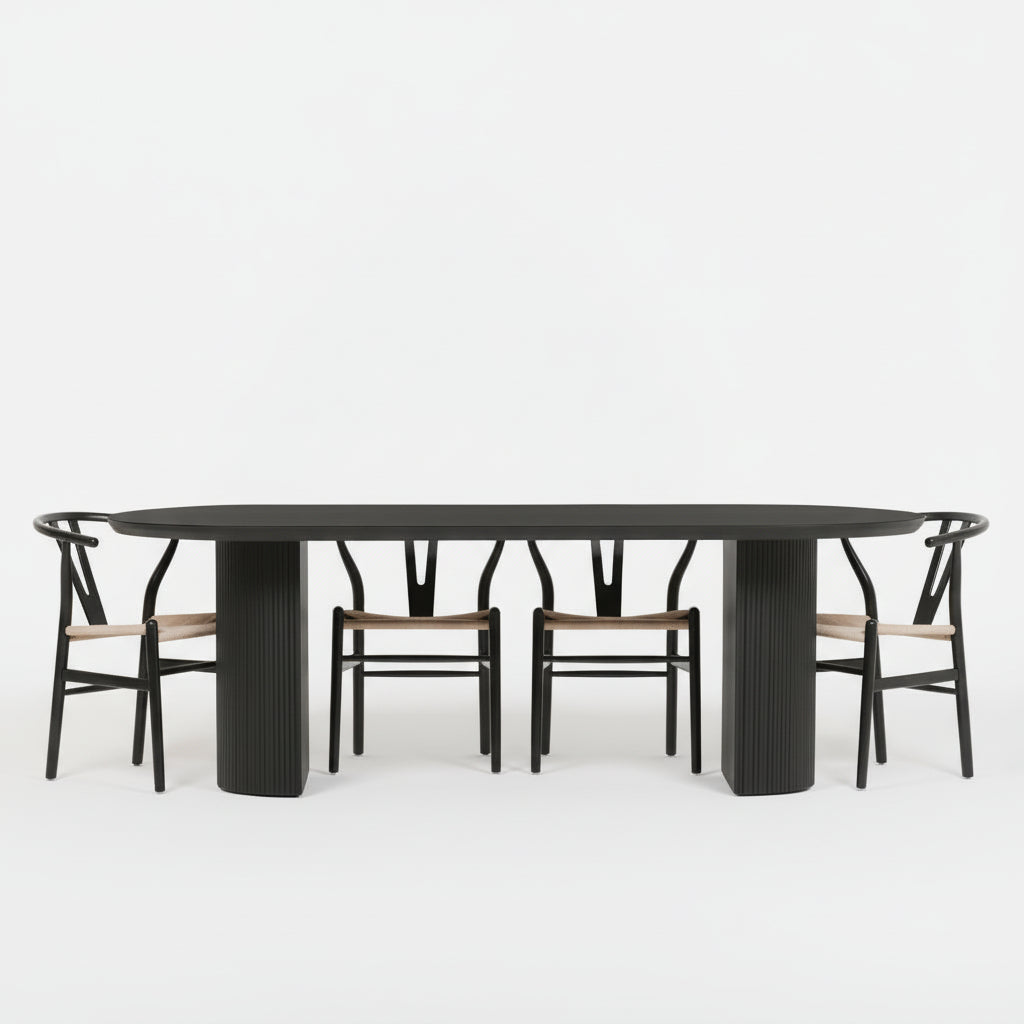 Dining room with a black oval table and chairs, featuring decorative items and a wall art piece.